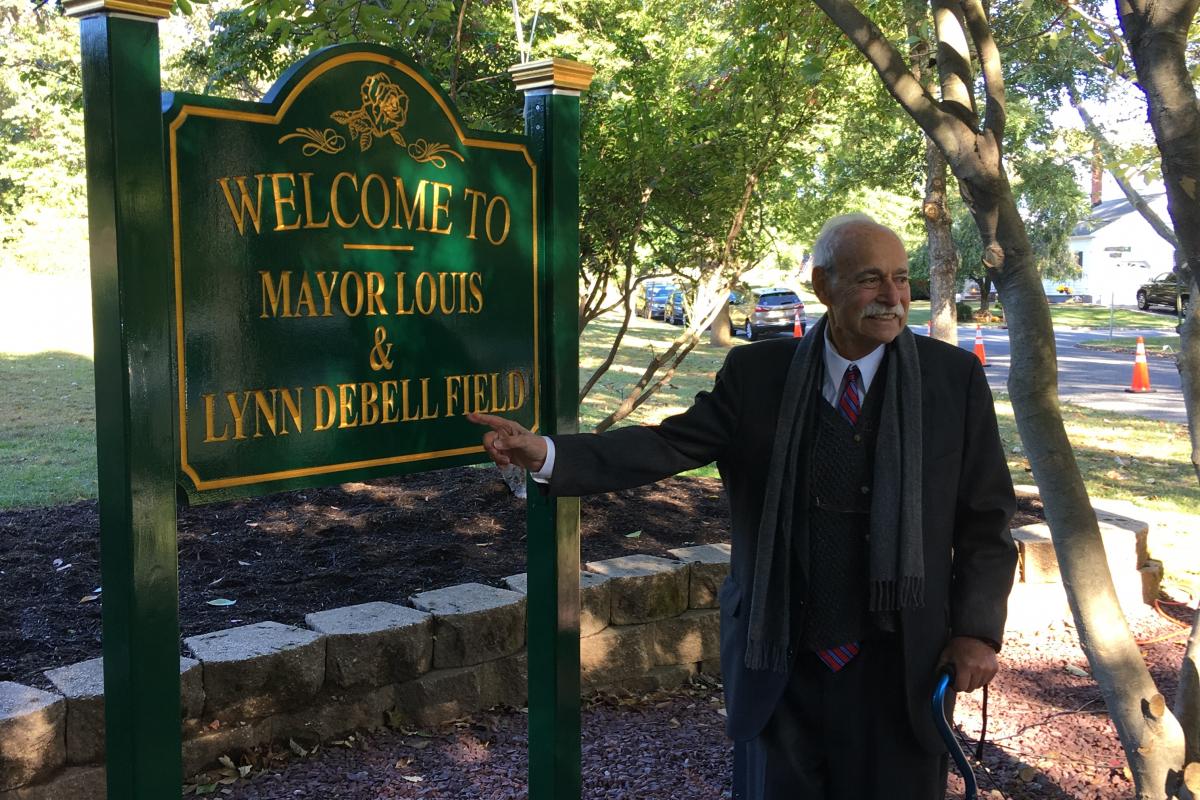 Mayor DeBell next to sign